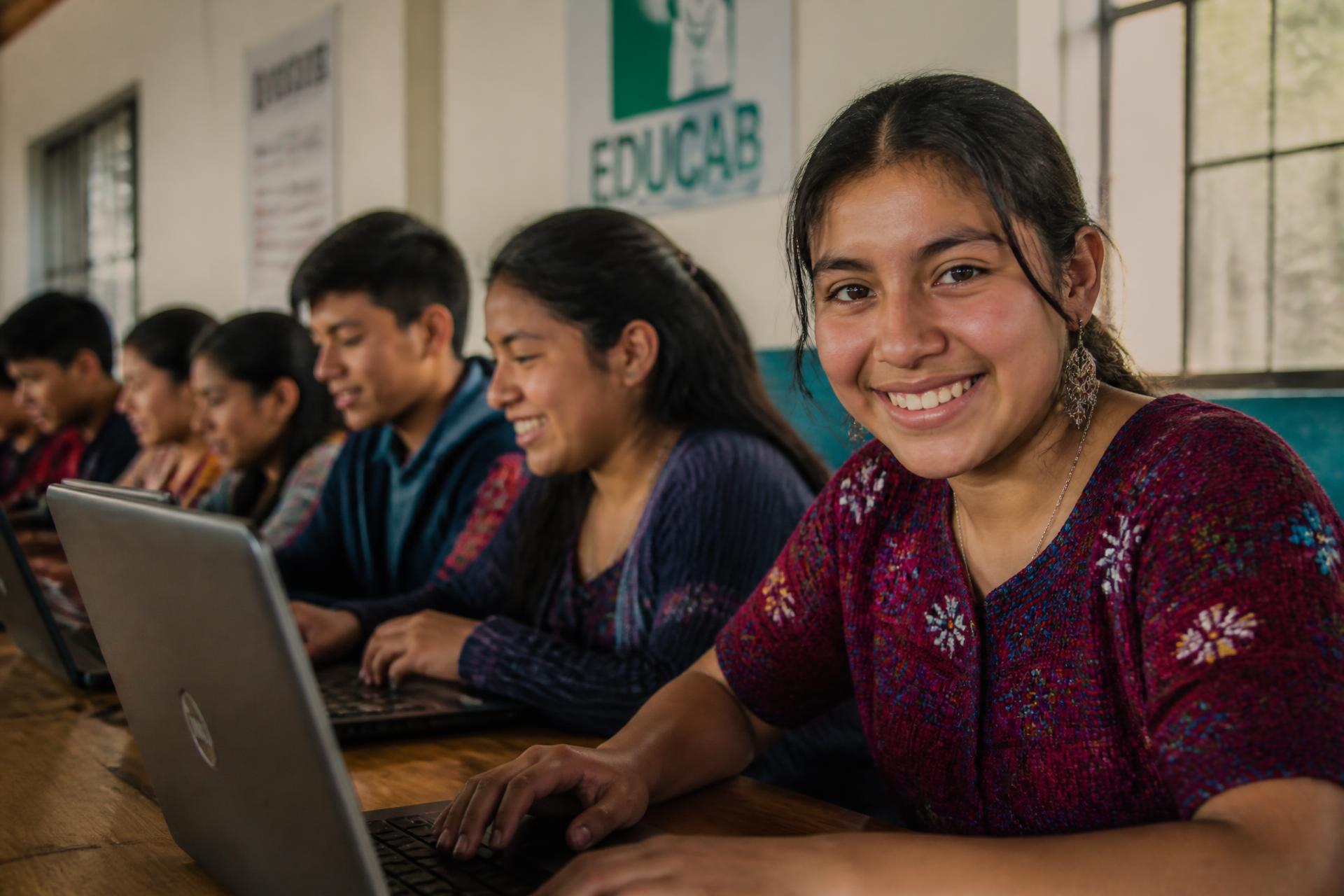 Jóvenes guatemaltecos trabajando con tecnología en un centro de formación